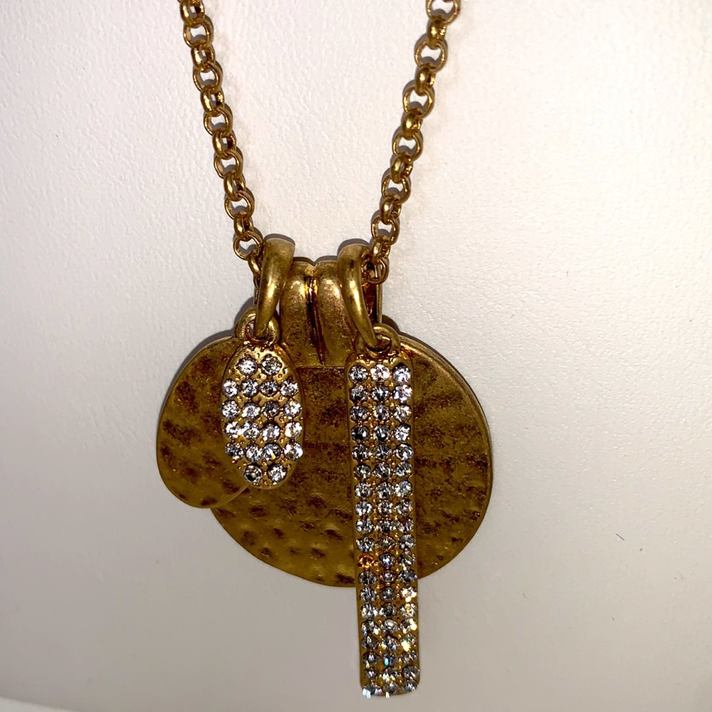 Brushed gold textured long pendant necklace with rhinestone embellishments.